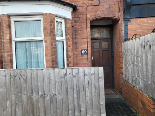 a wooden fence in front of a house with a door at Entire Flat city centre based. in Parkside