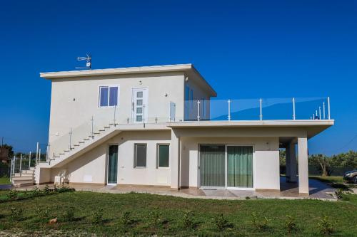 a large white building with a balcony on top at Cà del Re Holiday in Partinico