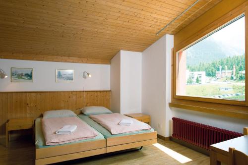 Pontresina Youth Hostel tesisinde bir odada yatak veya yataklar