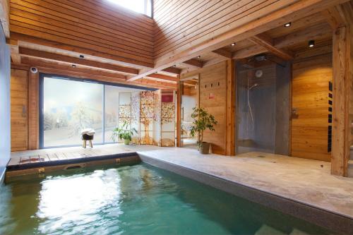 une maison avec une piscine au milieu d'une pièce dans l'établissement Chalet le 1700, à Les Deux Alpes