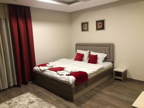 um quarto com uma cama com almofadas vermelhas em As Lux Apartmani Kopaonik em Kopaonik