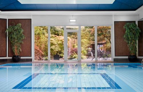 a large swimming pool in a building at Careys Manor Hotel & SenSpa in Brockenhurst