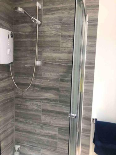 a shower with a glass door in a bathroom at The Studio on The Green in Egham