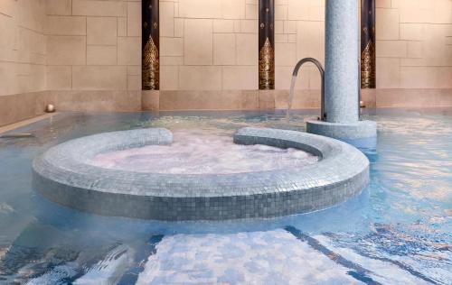 a hot tub in a fountain in a building at Careys Manor Hotel & SenSpa in Brockenhurst