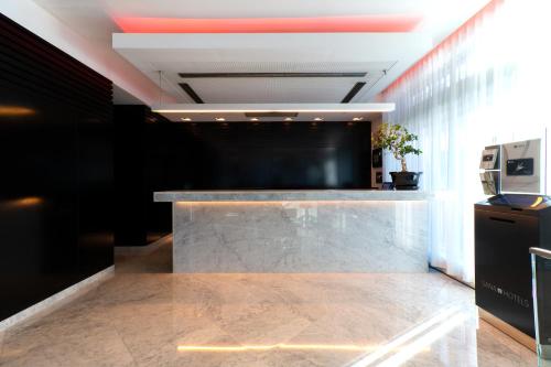 a lobby with a marble counter and a black wall at SANA Capitol Hotel in Lisbon