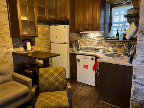 eine kleine Küche mit einem weißen Kühlschrank und einem Tisch in der Unterkunft Holiday home in Şirince Centre in Selçuk
