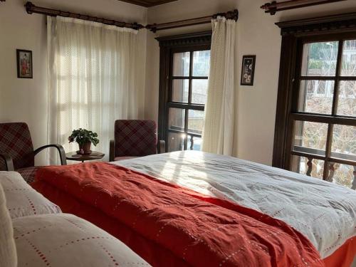 Schlafzimmer mit einem großen roten und weißen Bett mit Fenstern in der Unterkunft Holiday home in Şirince Centre in Selçuk