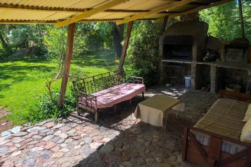 a bench sitting under a pavilion with a fireplace at Casa de montaña en un lugar mágico in Potrerillos