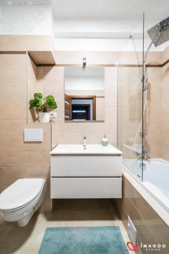 a bathroom with a sink and a toilet and a tub at Apartament Ghimbav_RK in Ghimbav