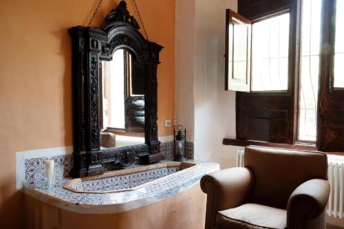 a bathroom with a large mirror and a chair at Relais Villa Giusso in Vico Equense