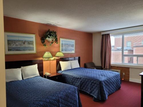 a hotel room with two beds and a window at Midtown Hotel in Parry Sound