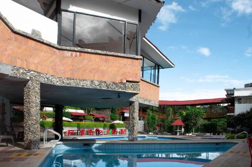 un edificio con piscina y un edificio con ventana en La Gran Estancia Hotel Campestre en Chachagüí