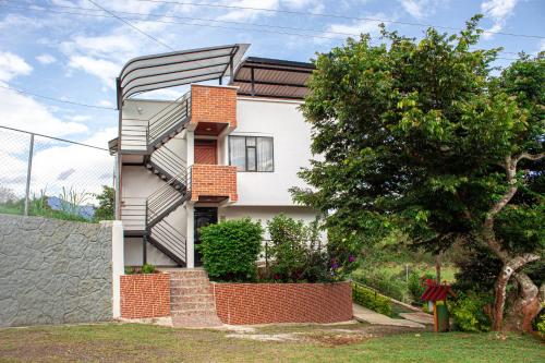 a house with a spiral staircase in front of a tree at La Gran Estancia Hotel Campestre in Chachagüí