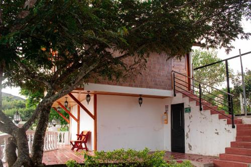 a house with a staircase and a tree at La Gran Estancia Hotel Campestre in Chachagüí
