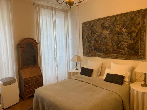 een slaapkamer met een bed met een schilderij aan de muur bij Appartement Artois in Parijs