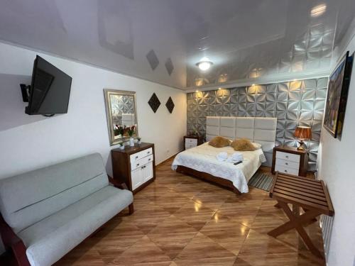 a bedroom with a bed and a couch and a tv at La Gran Estancia Hotel Campestre in Chachagüí