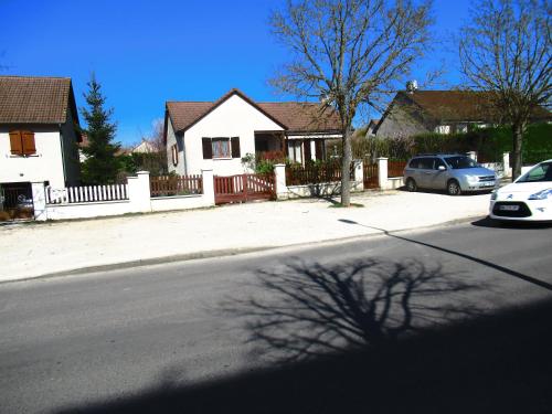 a house with a car parked on the side of a street at BELLEVUE in Quétigny