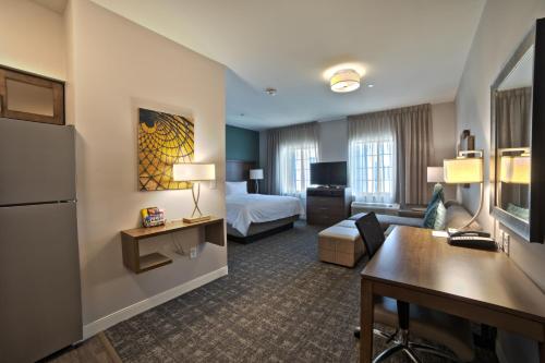 um quarto de hotel com uma cama e uma sala de estar em Staybridge Suites Houston - Humble Beltway 8 E, an IHG Hotel em Humble