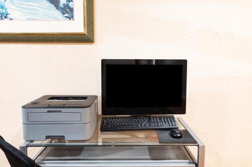 a desk with a laptop computer and a printer at Days Inn by Wyndham Del Rio in Del Rio