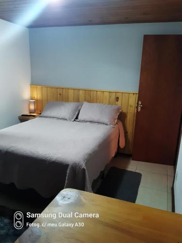 ein Schlafzimmer mit einem Bett in einem Zimmer in der Unterkunft Casa Souza in Camanducaia