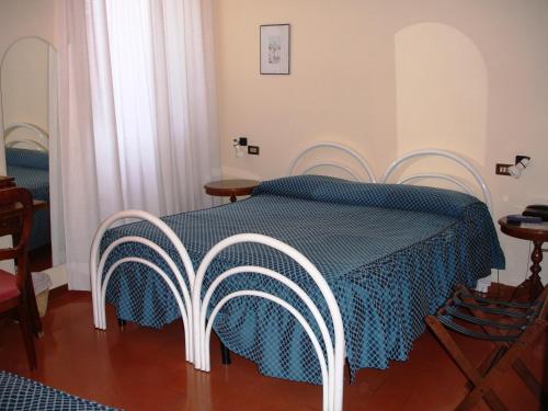 a bedroom with a bed with a blue blanket and chairs at Hotel Pallotta in Assisi