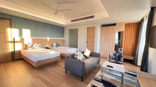 a hotel room with two beds and a couch at Aurora Boutique Hotel Imphal in Imphal