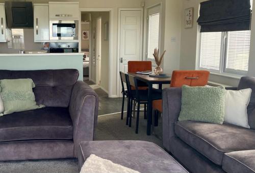 a living room with two couches and a table at Ribble Valley Lodge Retreat in Gisburn