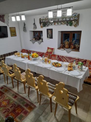 a dining room with a white table and chairs at Pensiunea IULIA in Rod