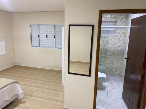 a bathroom with a mirror and a toilet in a room at Pousada Saint James in Águas de Lindóia