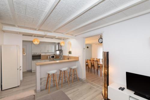 une cuisine avec un comptoir et un bar avec tabourets dans l'établissement Maison Cosy - Plage 5min - Parc Expo- Arena-Centre ville, à Mauguio