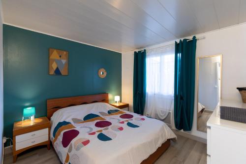 sypialnia z łóżkiem i niebieską ścianą w obiekcie Maison Cosy - Plage 5min - Parc Expo- Arena-Centre ville w mieście Mauguio