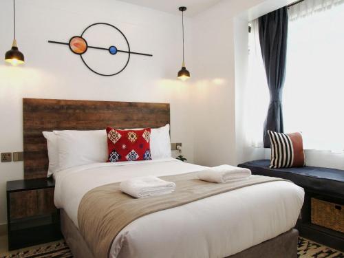 a bedroom with a large bed with a clock on the wall at Zendo Suite in Nairobi
