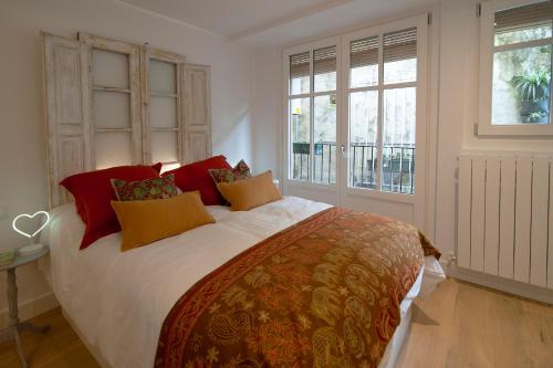 a bedroom with a large bed with red and yellow pillows at Aittitta Makurra etxea in Lekeitio