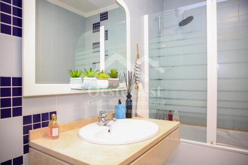 Un baño con lavabo, espejo y bañera. en Casa Menezes, en Lourinhã