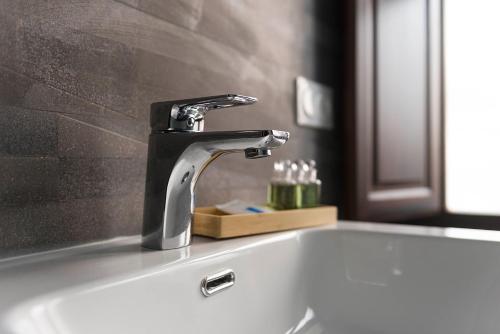 a bathroom sink with a faucet on top of it at Hotel Juancaballo in Úbeda