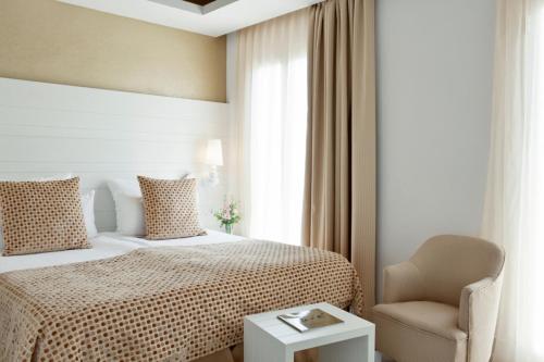 a hotel room with a bed and a chair at Hotel Illa d'Or & Club Apts 4* Sup in Port de Pollensa