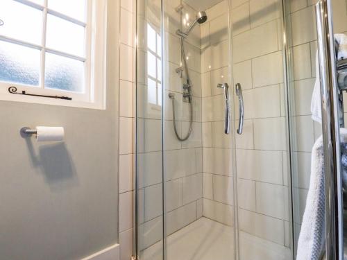 a shower with a glass door in a bathroom at Tillingham View in Rye