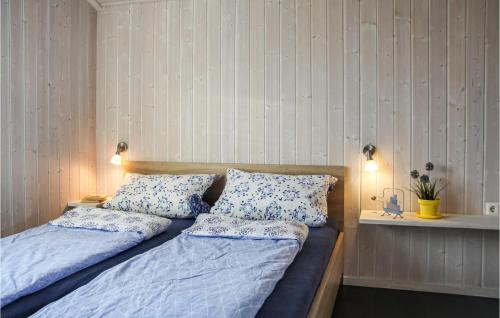 Schlafzimmer mit einem Bett mit blauer Bettwäsche und Kissen in der Unterkunft Strandpark 21 in Schönhagen