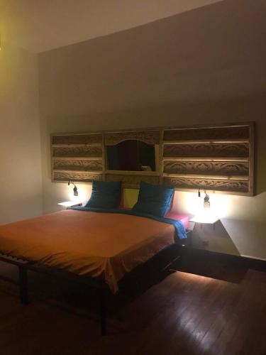 a bedroom with a large bed with two lights on it at La Casa Blu in Antananarivo