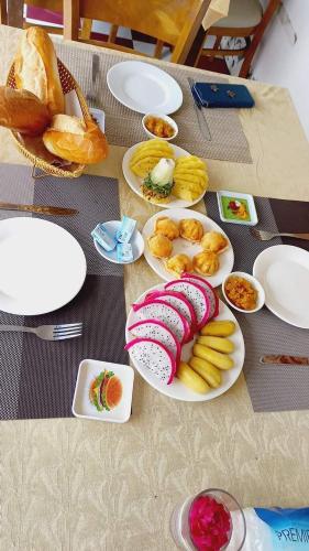 a table with plates of food and bread on it at Homestay Chez Moi in Can Tho