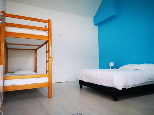 a bedroom with two bunk beds and a blue wall at Les chambres du Bistro du Canal in Pleyben