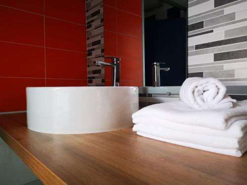 um lavatório de casa de banho com toalhas num balcão de madeira em Les chambres du Bistro du Canal em Pleyben