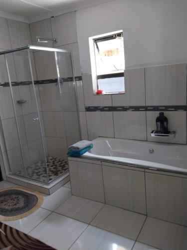a bathroom with a shower and a bath tub at Vaal holiday home in Vanderbijlpark