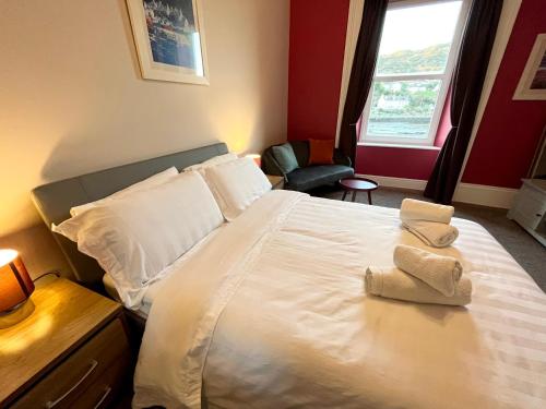 Un dormitorio con una cama blanca con toallas. en The waterfront, en Tarbert