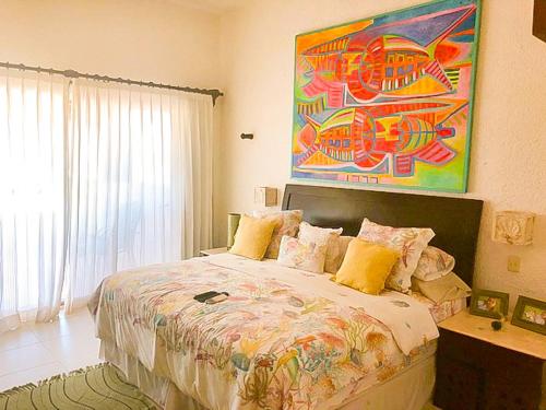 チクシュルーブにあるVilla Sirosの壁に絵が飾られたベッドのある寝室