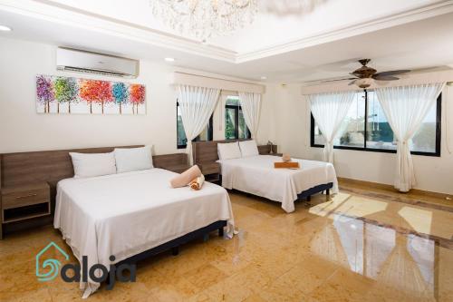 - une chambre avec 2 lits et un lustre dans l'établissement 5BR Sunset villa with lagoon view in the Hotel Zone, à Cancún