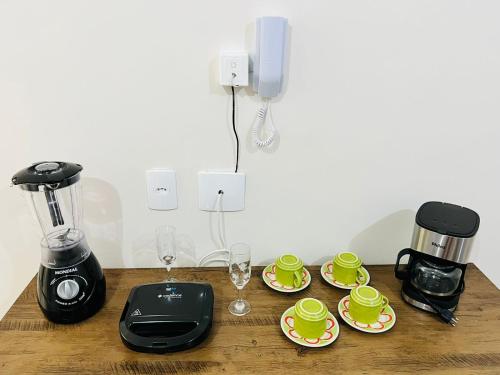 a table with two coffee makers and cups on it at Apartamento lugar de Paz in Salvador