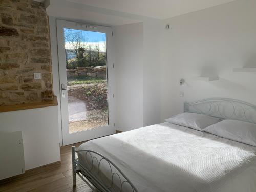sypialnia z łóżkiem i dużym oknem w obiekcie La Combe aux Fées w mieście Saint-Côme-dʼOlt