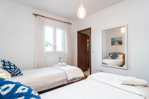 a bedroom with two beds and a mirror at ES GANXO HOUSE PORTO CRISTO in Porto Cristo