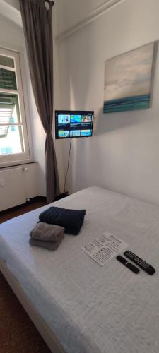 a bedroom with a bed with two remote controls on it at Genova Rooms Brignole B in Genoa